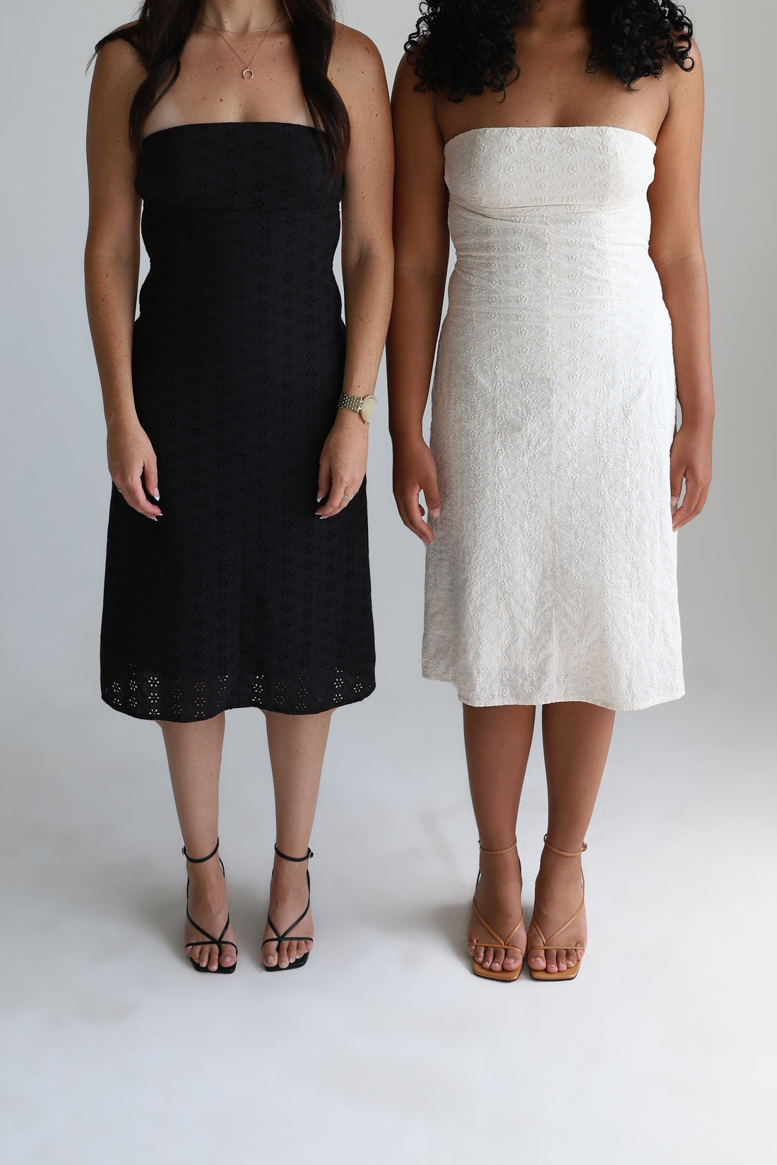 Two girls wearing black and white versions of a strapless dress.
