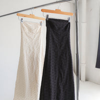 Two dresses hanging on a clothing rack.