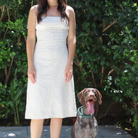 Model standing up straight facing the camera next to a dog.